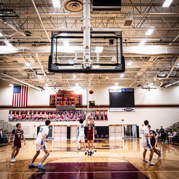 Basketball players running a play during a JV game