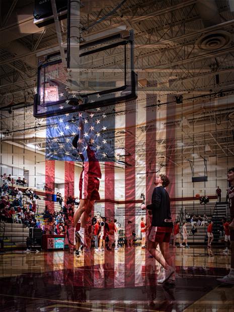 Basketball player finishing a dunk under the hoop