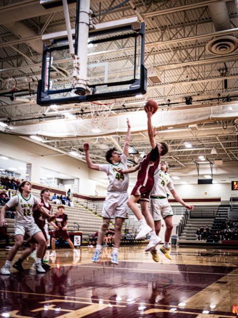 Basketball player finishing a contested layup