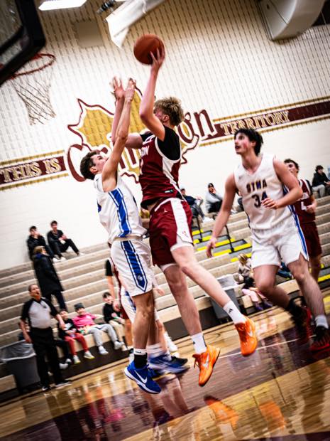 Basketball player finishing through contact near the hoop